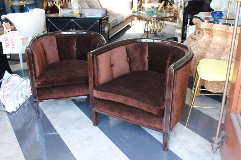 Exquisite pair of tub chairs in a mahogany colored velvet. Interior of chairs are tufted with covered buttons. Trim and legs are walnut with French polish. These Deco Inspired chairs are small scale and perfect for any space.