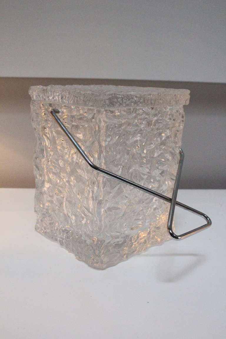 Wilardy Lucite ice bucket that has the appearance of ice. This clever bar accessory is a conversation starter. The lid is attached on the back, with a chrome handle. Dimensions of box: 6.5
