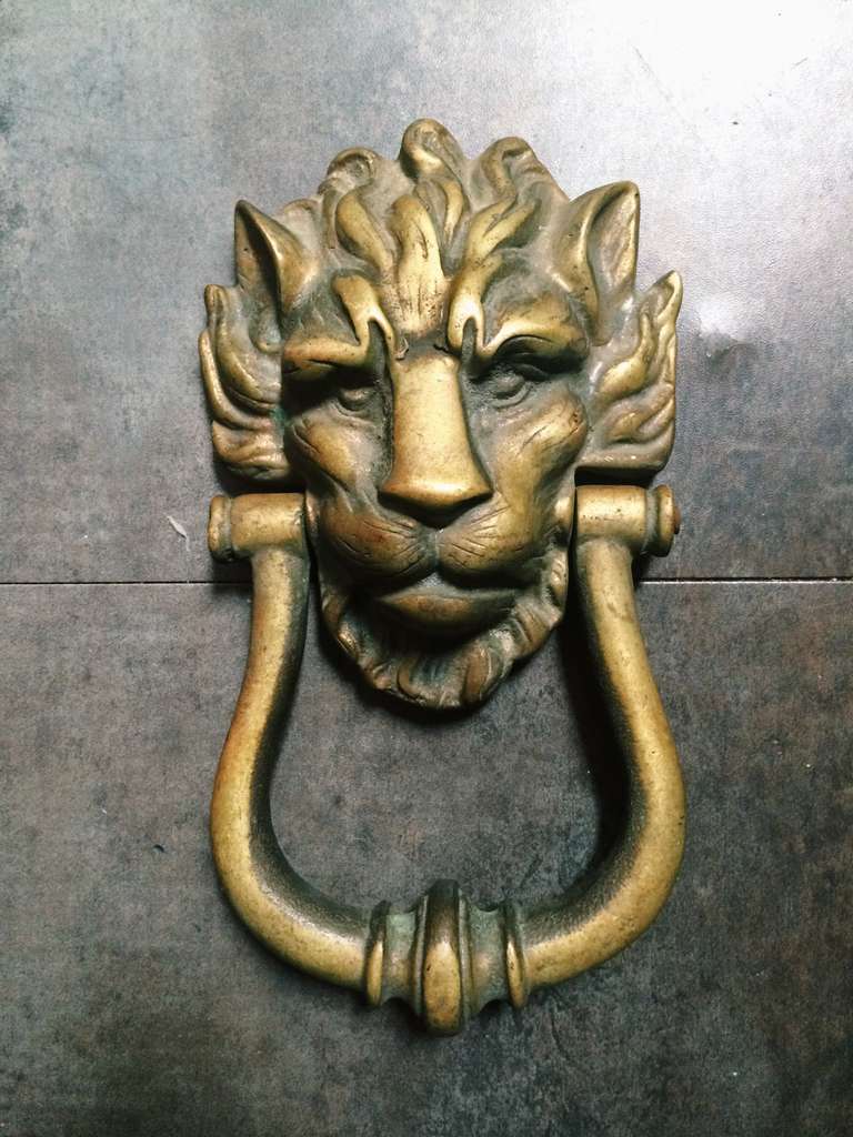 A brass lion's head door knocker. A great piece to top a pile of coffee table books or hung on the wall!