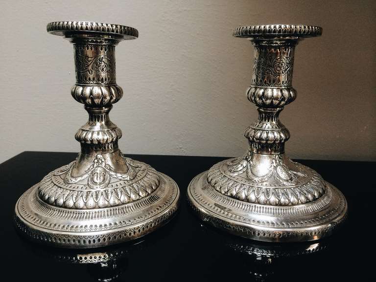 A pair of sterling silver candlesticks with highly detailed repoussé.