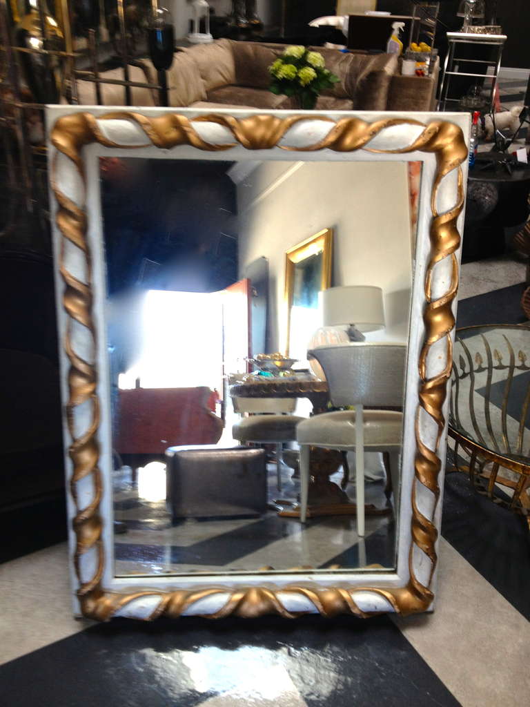 A whimsical and weathered paint and gilt mirror, this is a great mirror with a scroll detail reminiscent of a may pole or circus tent, the design is wonderful and the aged, worn carved wood looks great, perfect for an eclectic mix and certainly a
