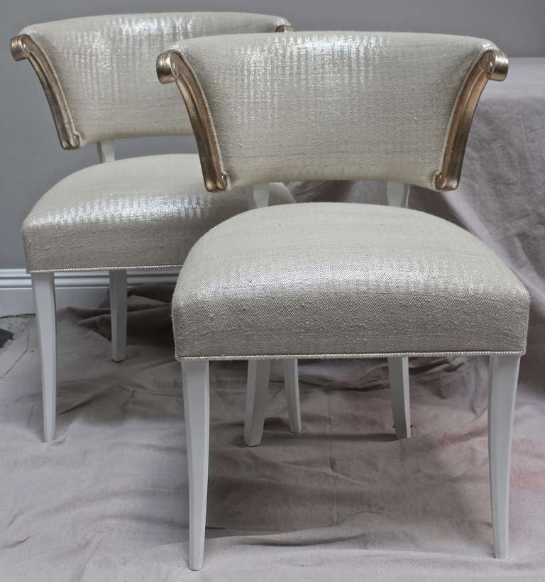 Pair Klismos side chairs with silver leafed arms and white lacquer legs, silver.

Darren Ransdell design.