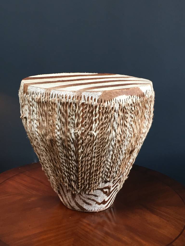 Brown and white zebra skin drum or table with braided detail down the side. The drum works perfectly, so beat yourself to Zimbabwe and the Congo, or use this stunner as a side table with a twist.