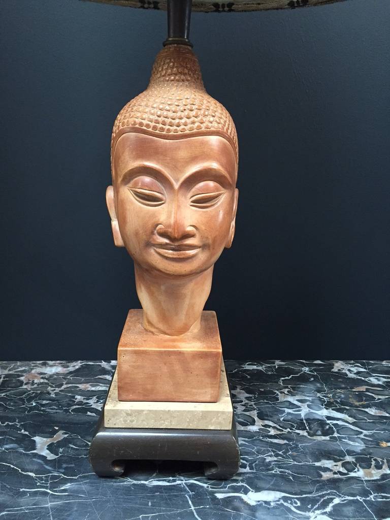 Beautifully carved wooden Buddha head with tribal shade. 

Silk cord and sliding on-off switch inside the shade.