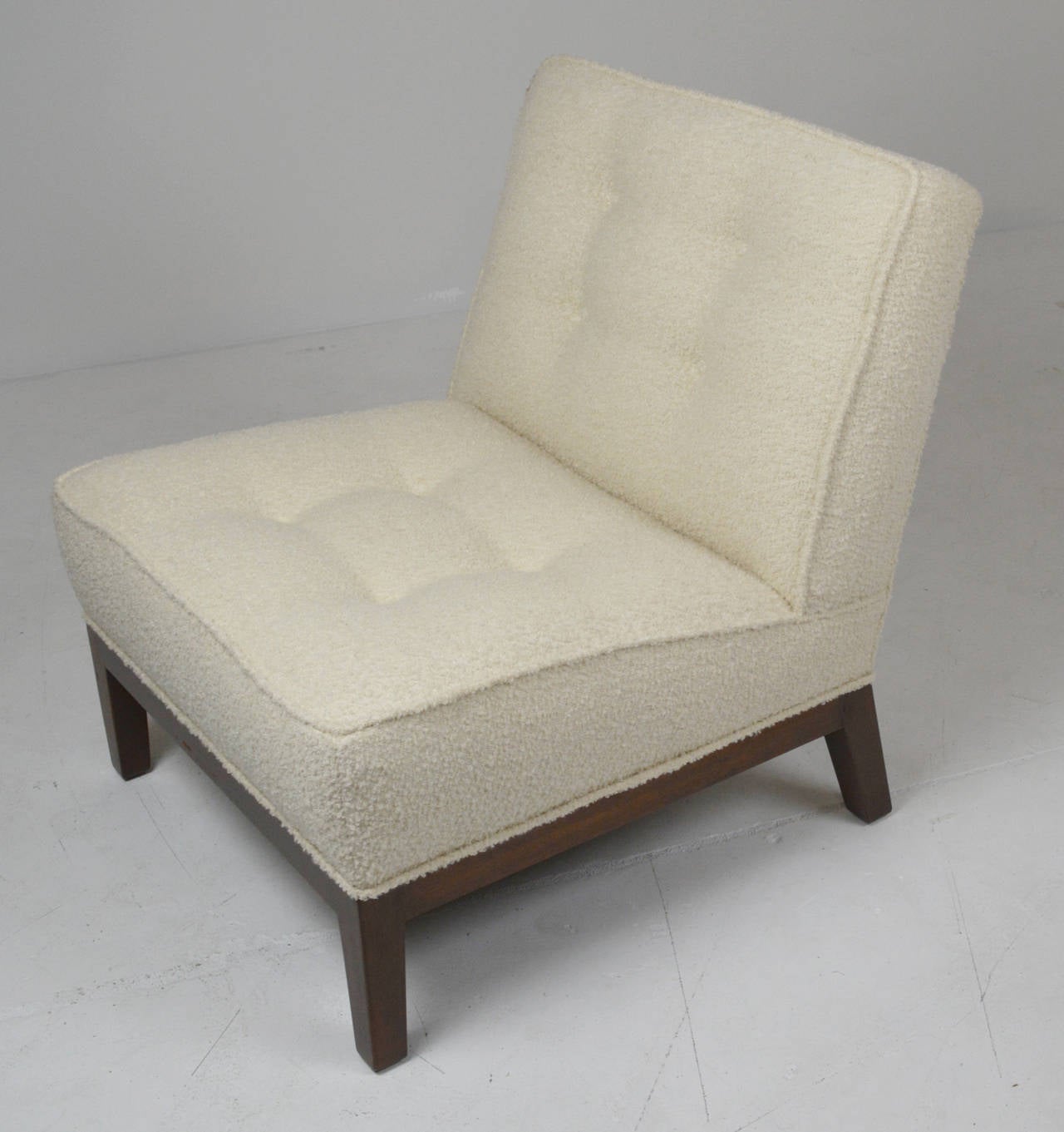 slipper chair by Edward Wormley for Dubar. Button tufted tight seat and back in ivory boucle. Wood base refinished in dark walnut