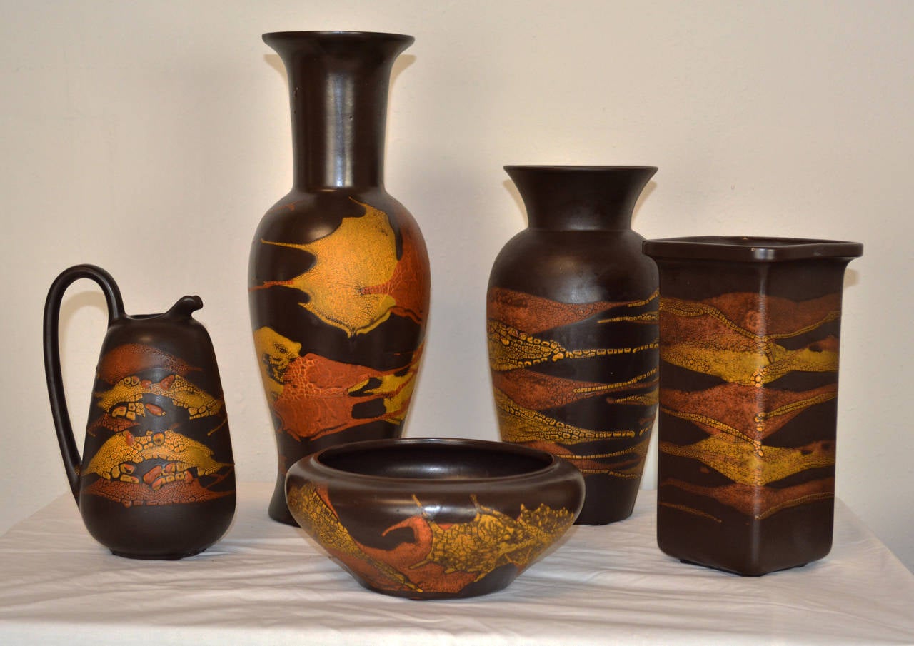 A collection of 1970's pottery by Royal Haeger from the "Earth Wrap" line. Gold and burnt orange lava glaze on a matte brown ground. Ten pieces available, sold in sets of 5.