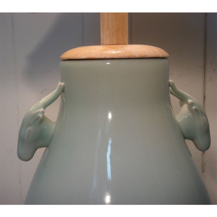 Pair of wonderful celadon porcelain lamps with handles in the form of rams heads or deer heads. Beautiful color color and glaze. Original limed wood bases and caps. Height is to top of socket, shades are for display only