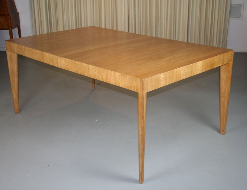 Elegant extending dining table by Robsjohn Gibbings for Widdicomb. Bleached mahogany with sculpted legs set on the diagonal and rounded corners. Apron is 3.5