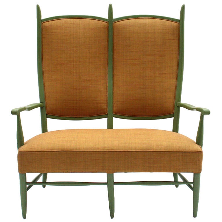 A tall and sculptural settee with tapered wood arms and back, often attributed to Edward Wormley for Dunbar. Designed by Maxwell Royal in the 1950's. Highly stylized, it was influenced by the designs of Italian furniture maker Paolo Buffa. Hand