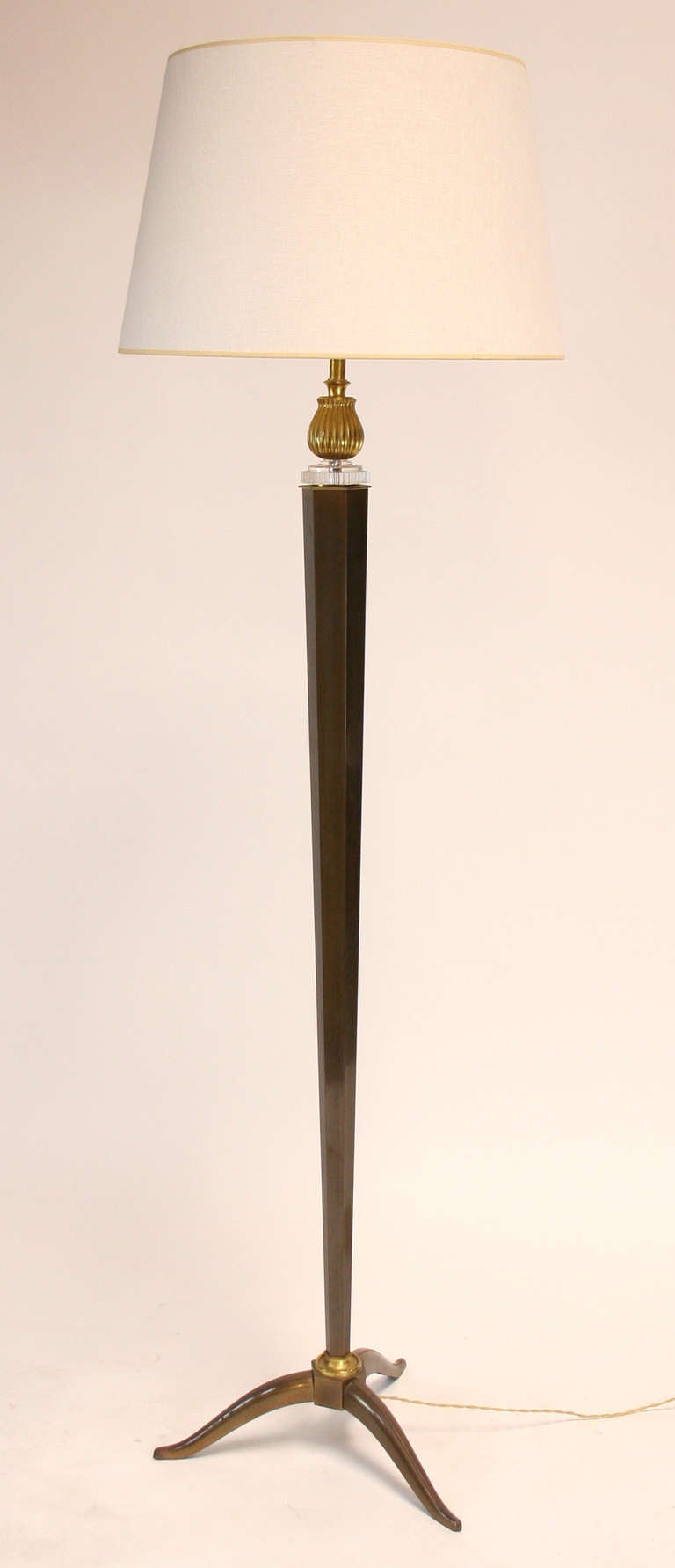 Monumental floor lamp with hexagonal, tapered shaft on shaped tripod feet with lucite and gilt brass detailing. 63 3/4" to top of socket, 72 1/2" H, 3" W, 20" dia. @ base. Shade shown for showroom use only