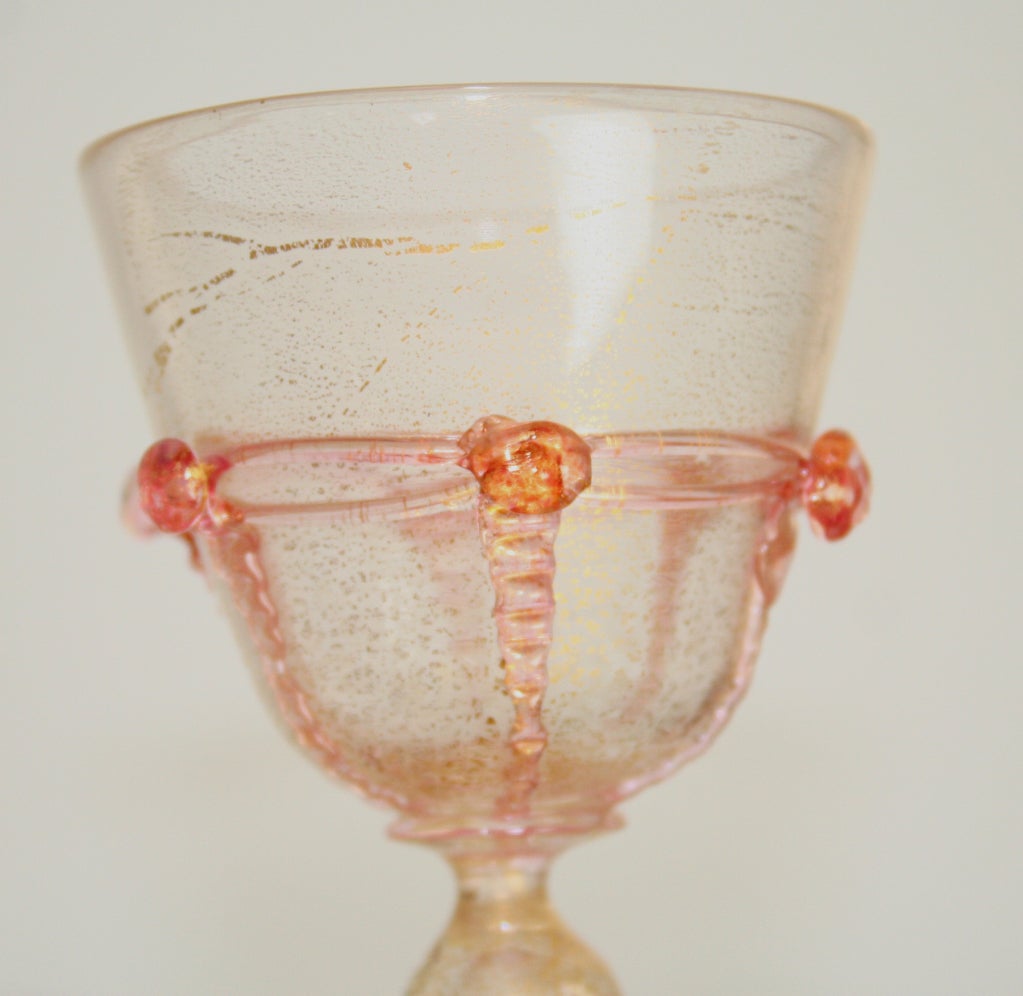 Bellissimo set di bicchieri veneziani composto da 2 set di 4 calici, bicchieri da sherry e coupe. Venduto come set da quattro.
Inclusioni dorate in vetro trasparente con rosette applicate in vetro rosa. Altezza dei calici 6,3/4