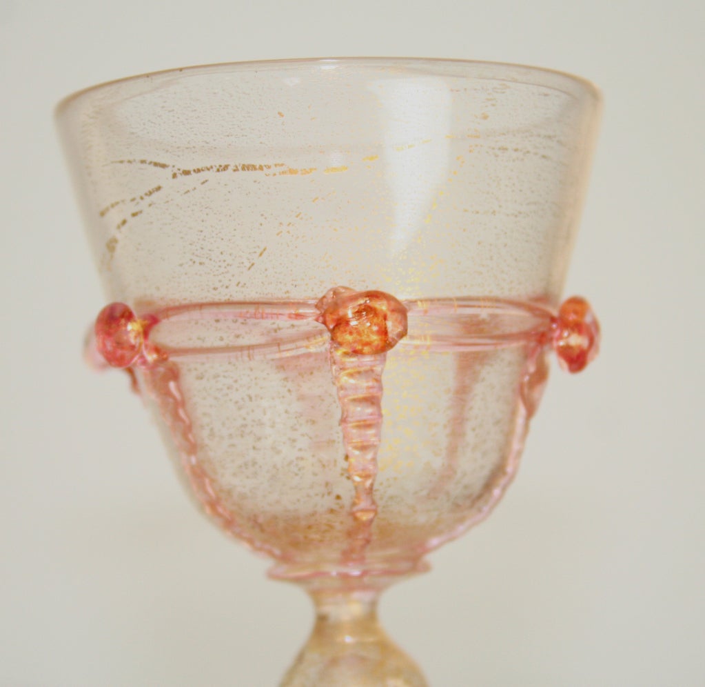 Beautiul set of Venetian stemware comprising 2 sets of 4 goblets, sherry glasses and coupes. Sold as a set of four.
Gold inclusions in clear glass with applied pink glass rosettes. height of goblets 6 3/4in; height of coupes 4 3/4in; height of