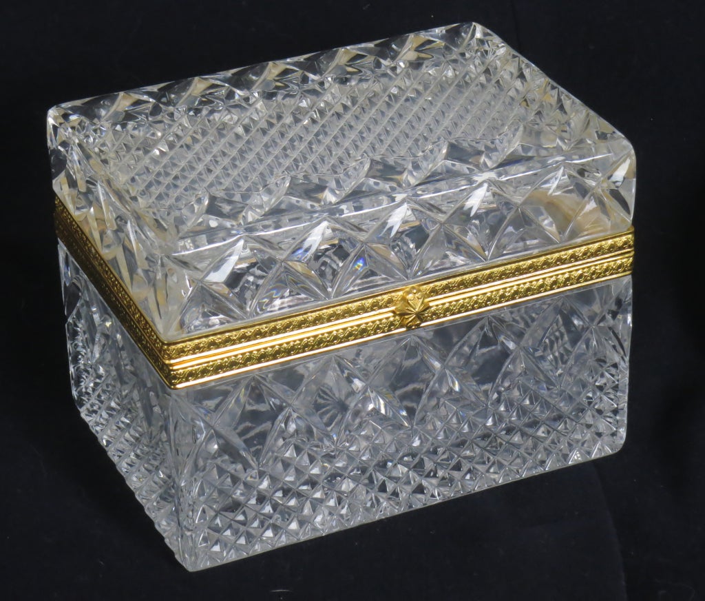 Gorgeous antique French cut crystal jewelry casket or box circled by ornate gilt bronze mounts. The crystal is cut in an all over diamond point pattern accented by a 16-point starburst at the bottom. Lovely gilt bronze mounts adorned in an 'egg &