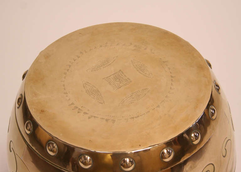 Chic brass garden seat with large domed rivet heads around the circumference, top and bottom. Two tone brass decoration on sides and incised Asian motif on the lid