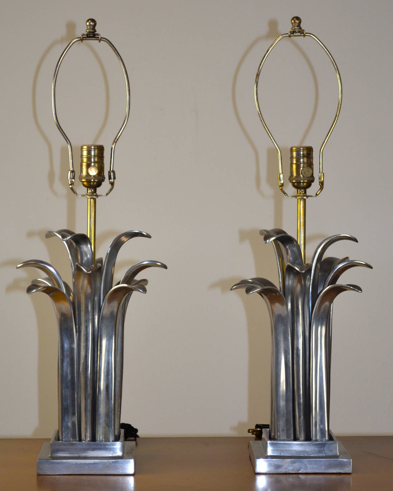 Un'incredibile coppia di lampade composta da singoli steli o foglie di metallo che circondano un'asta centrale. Su una base quadrata in metallo abbinata. I paralumi non sono inclusi, sono solo da esposizione. Francese, nello stile di Maison Charles