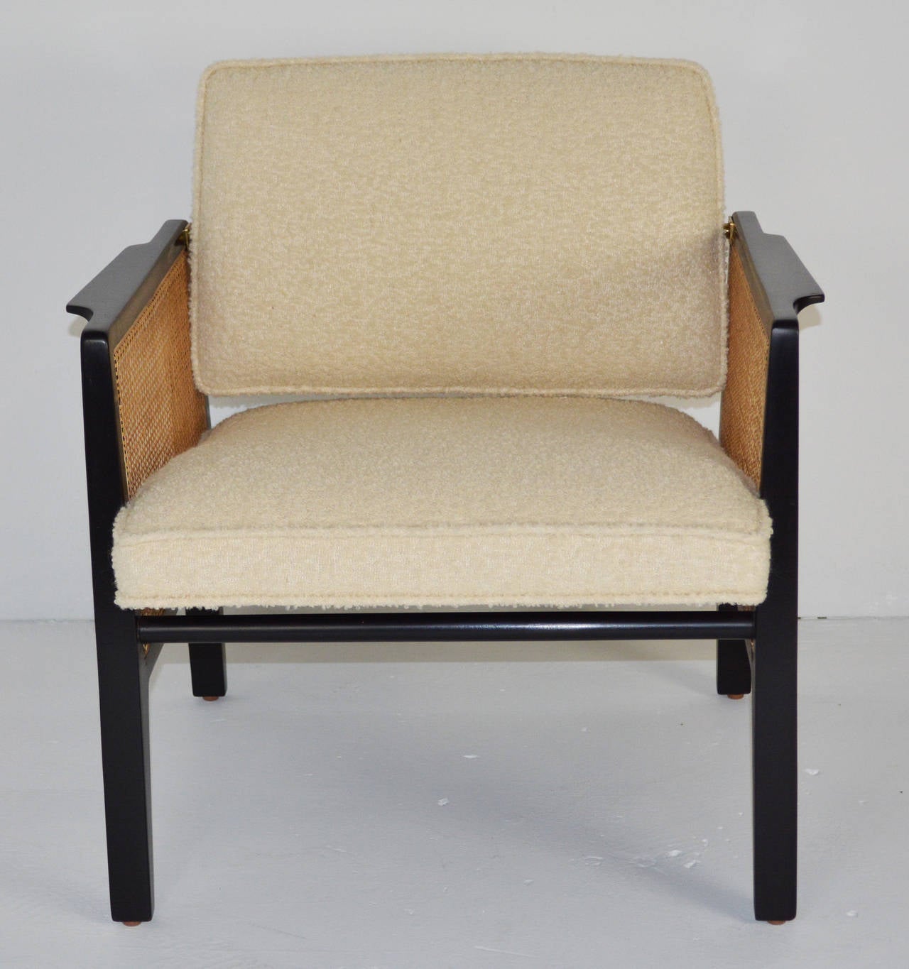 Armchair Model 5513 by Edward Wormley for Dunbar. Pivoting back and sculpted seat make for a comfortable small scale chair. Caning has been replaced and the chair newly upholstered in ivory wool boucle.