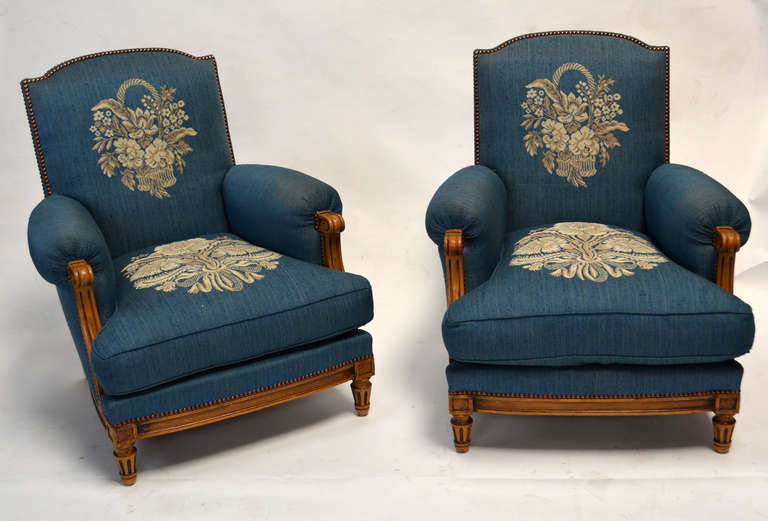 A lovely pair of French club chairs in the manner of Jean Pascaud and Maison Jansen. Exposed wood base and arm detail in the Louis XVI style. Beautiful proportions and exceptionally comfortable!