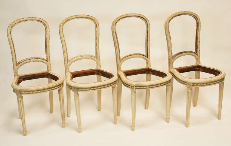 A good set of four painted Louis XVI style balloon back chairs. Originally caned, then upholstered. Could be re-caned or reupholstered. Lovely carving with good depth and clarity.