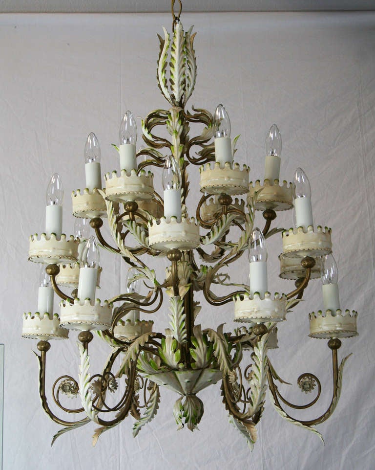 A lovely 18 light Italian tole chandelier. Antiques white paint with green and gold accents. Very sculptural. Lovely matching canopy. Palm Beach Style.