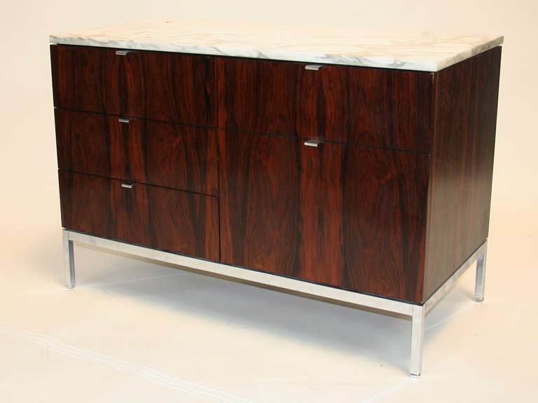 Iconic cabinet by Florence Knoll, circa 1961, #2542M. Four box drawers (each with one removable partition), one full extension file drawer with two metal bars for hanging files. In Rosewood with Calacatta marble top and polished chrome base. The
