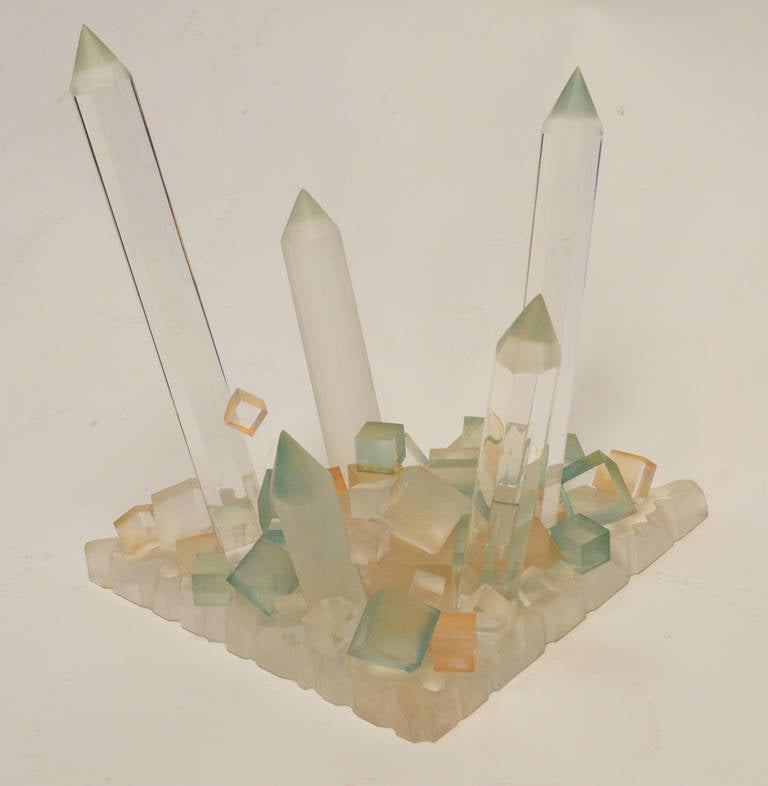 A tabletop sculpture of 'crystals' composed of frosted and clear Lucite, some of which have a blush of color.