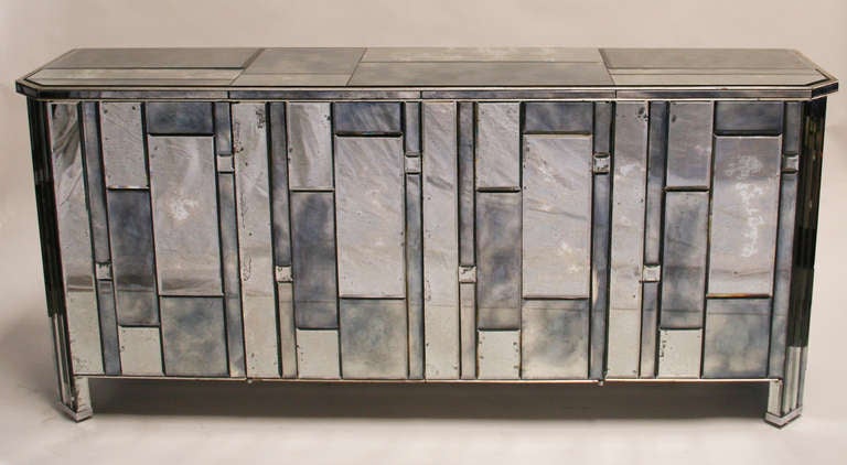 Exceptional custom 4 door buffet covered in beveled, antiqued mirror by William Lyons Design Craft, Inc, circa 1975. Silver leafed wood trim. Holes have been cut into the back  for cord access. A separate matching pair of side cabinets are