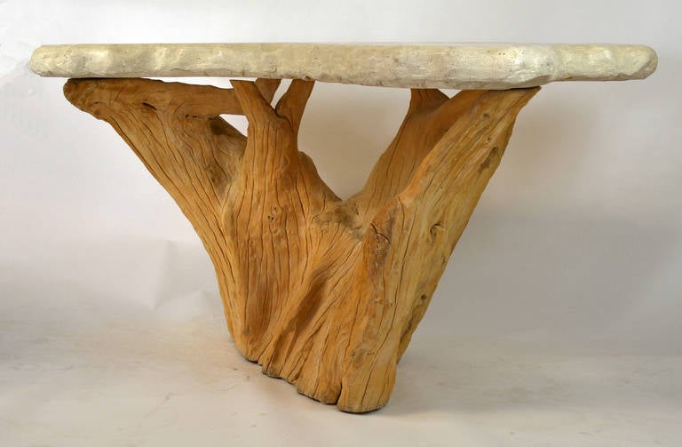 A large, sculptural console with tree trunk base and faux stone top by Michael Taylor.
