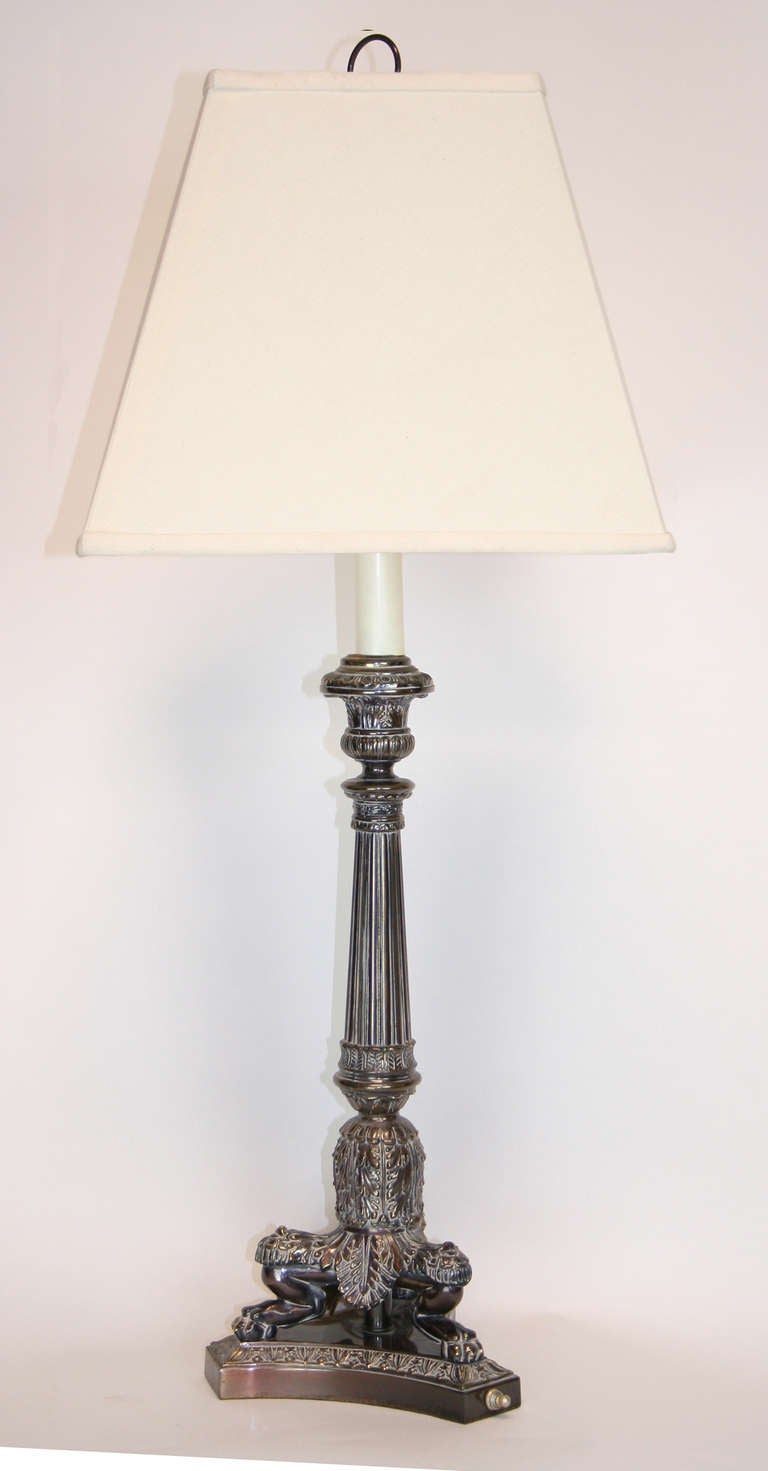 Regency style silverplate lamp with tall foliate and ribbed column, tripod paw feet on concave-shaped base .
