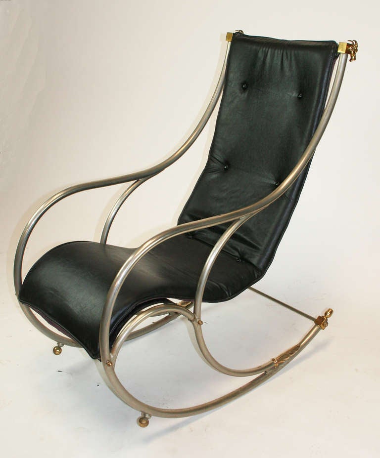 Exceptional steel rocking chair with brass accents and leather sling seat. Rams heads accentuate the back. Metal "Made in Italy" tag on one arm.