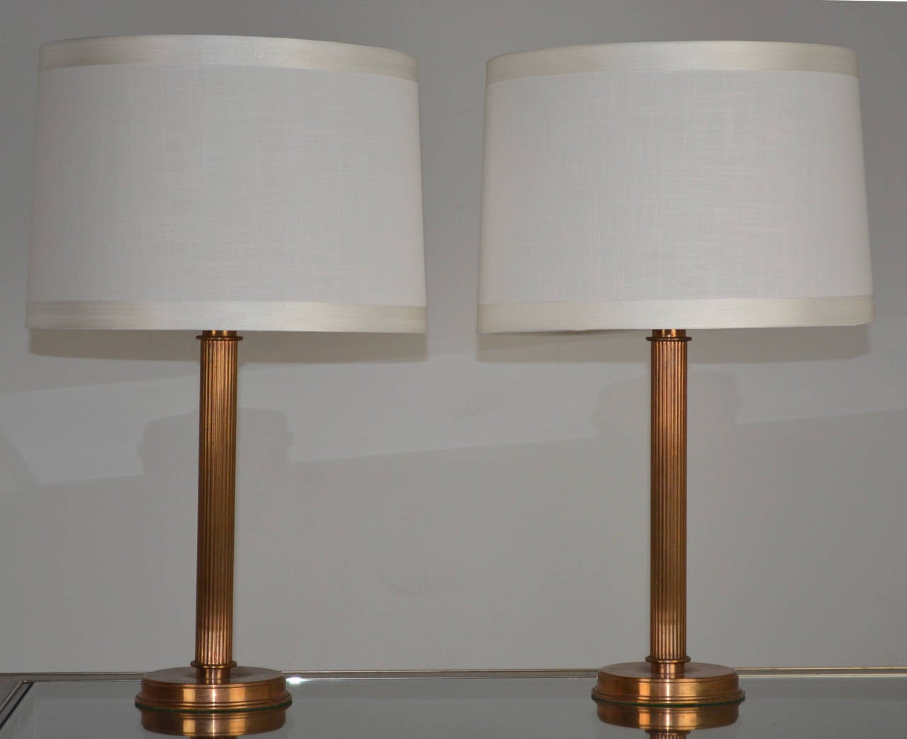 Interesting pair of lamps with a copper finish comprising a reeded column on a circular disc base