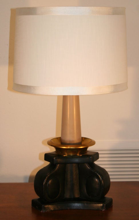 Table lamp with black leather base of classical scroll form with gilt bronze and painted wood faux candle. With original aluminum uplight and two small European socket lights on the side. Shade is for display only.