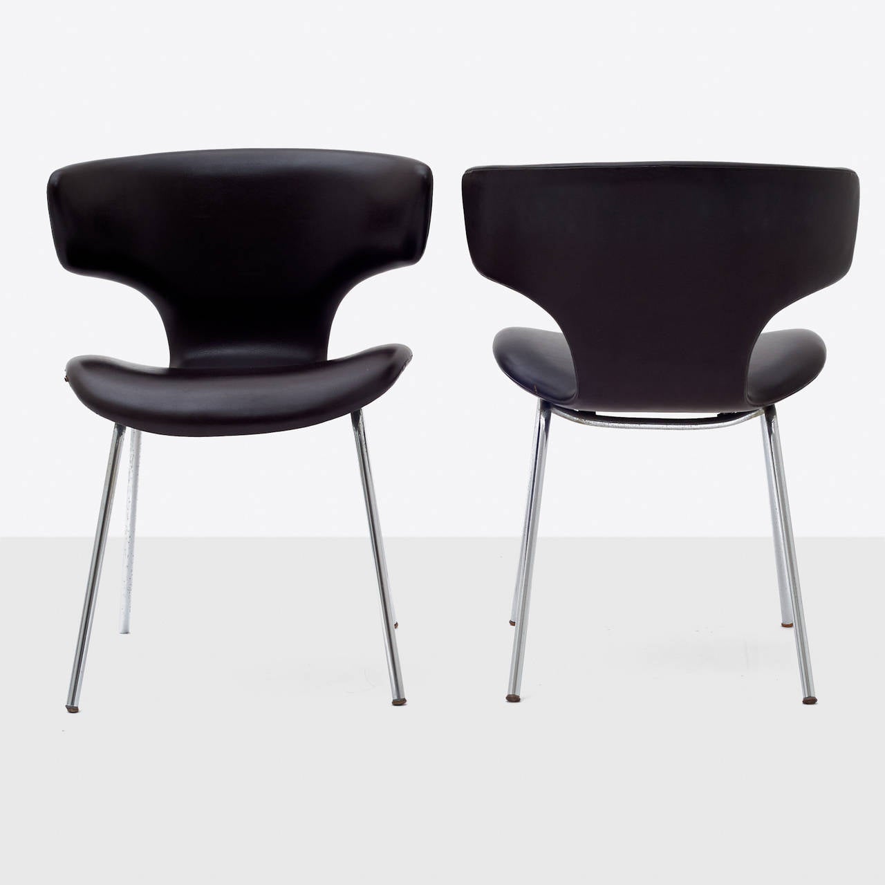 A pair of chairs by Isamu Kenmochi upholstered in dark brown
leather with chrome plated steel legs.