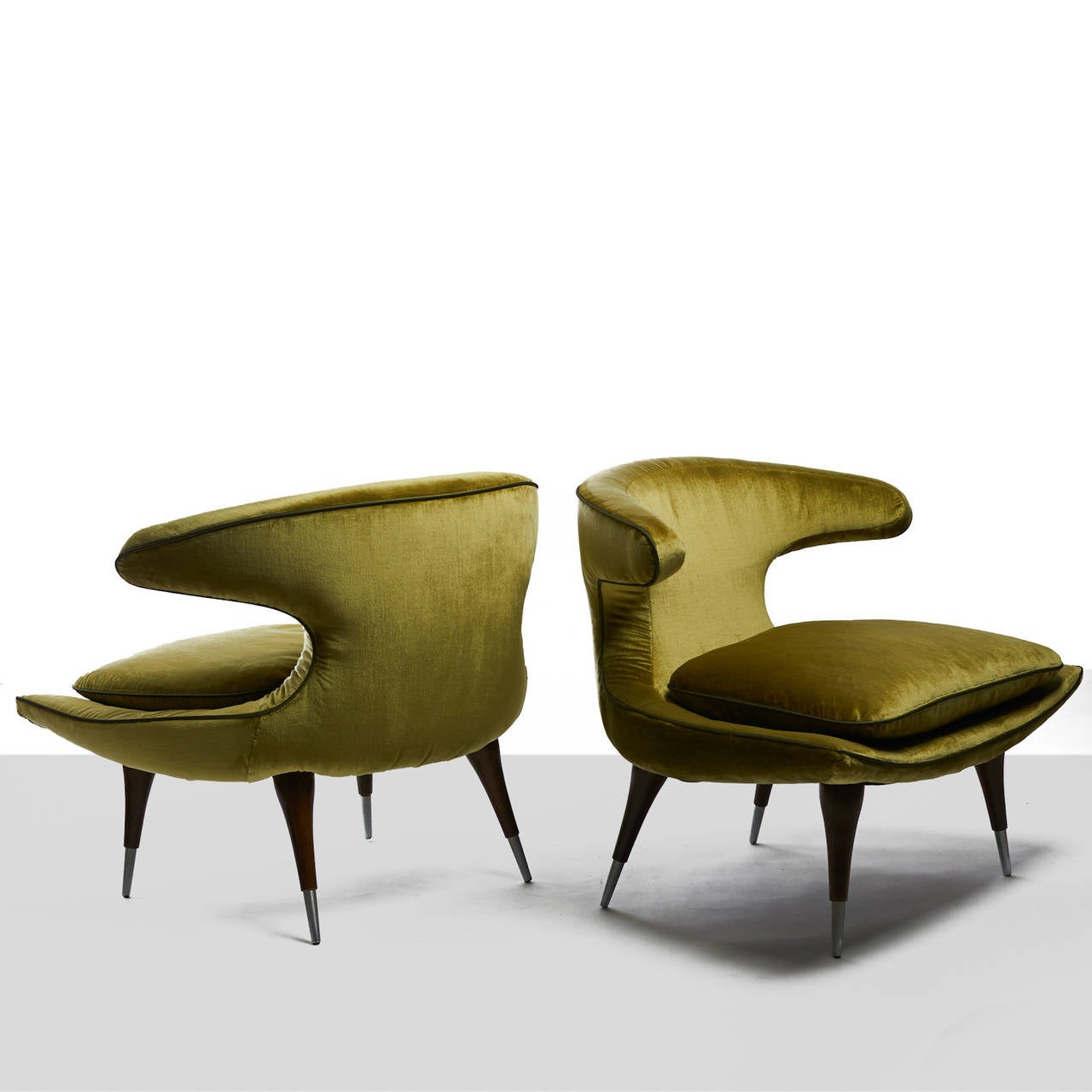 A pair of Horn lounge chairs by Karpen of California.
Loose cushion is surrounded by curved arms and set atop angled
walnut legs with steel caps. Upholstered in a Holland and Sherry silk velvet, with contrast silk trim.