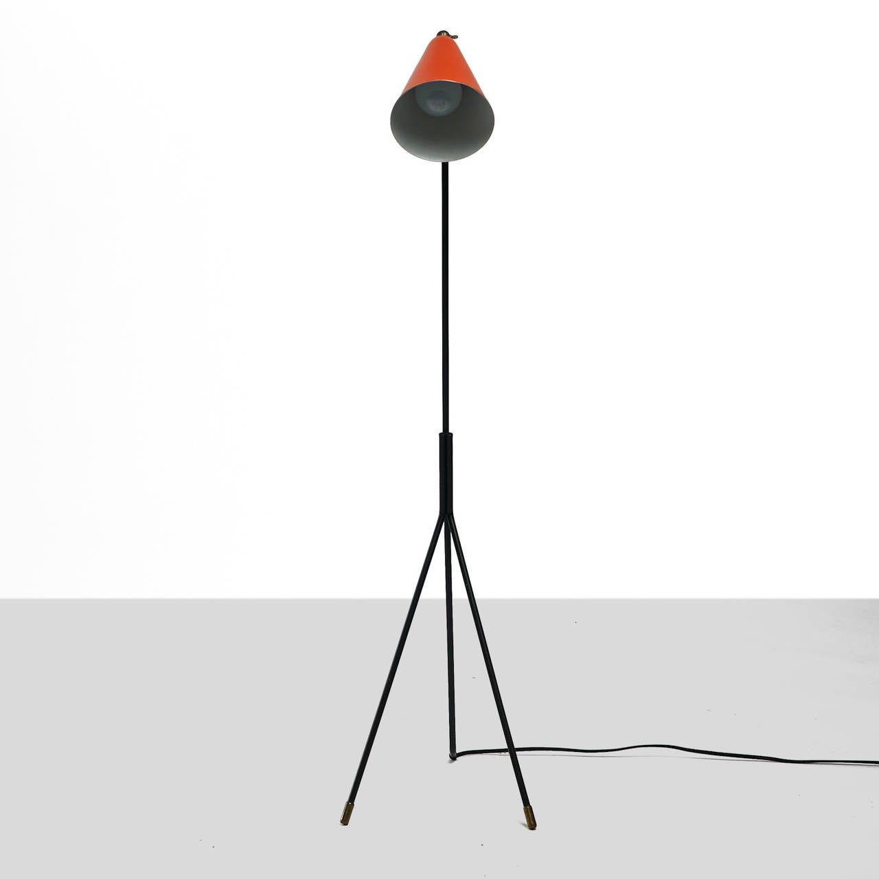 A floor lamp by Svend Aage Holm Sorensen. Orange lacquered adjustable shade with brass joint. Black lacquered three-leg base with brass caps. Newly rewired.