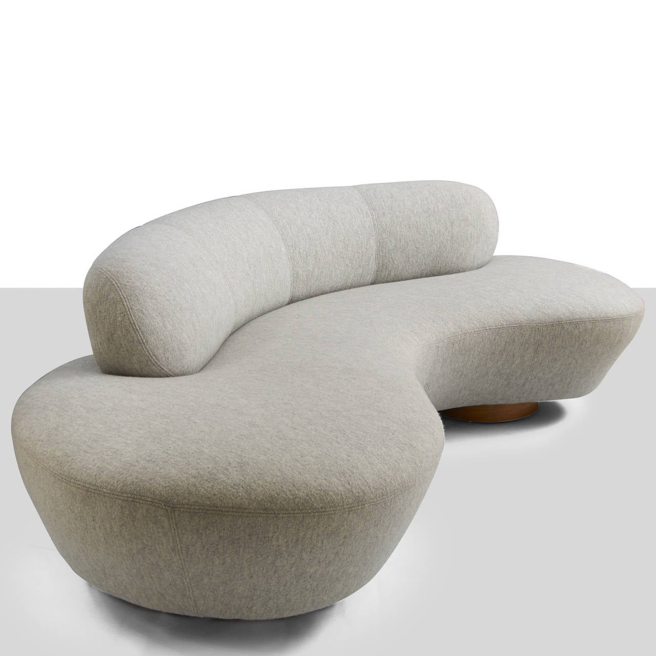 A serpentine sofa by Vladimir Kagan for Kagan-Dreyfuss. Walnut base with a supporting foot of Lucite. Newly restored in a heathered grey boiled wool with double top stitching.