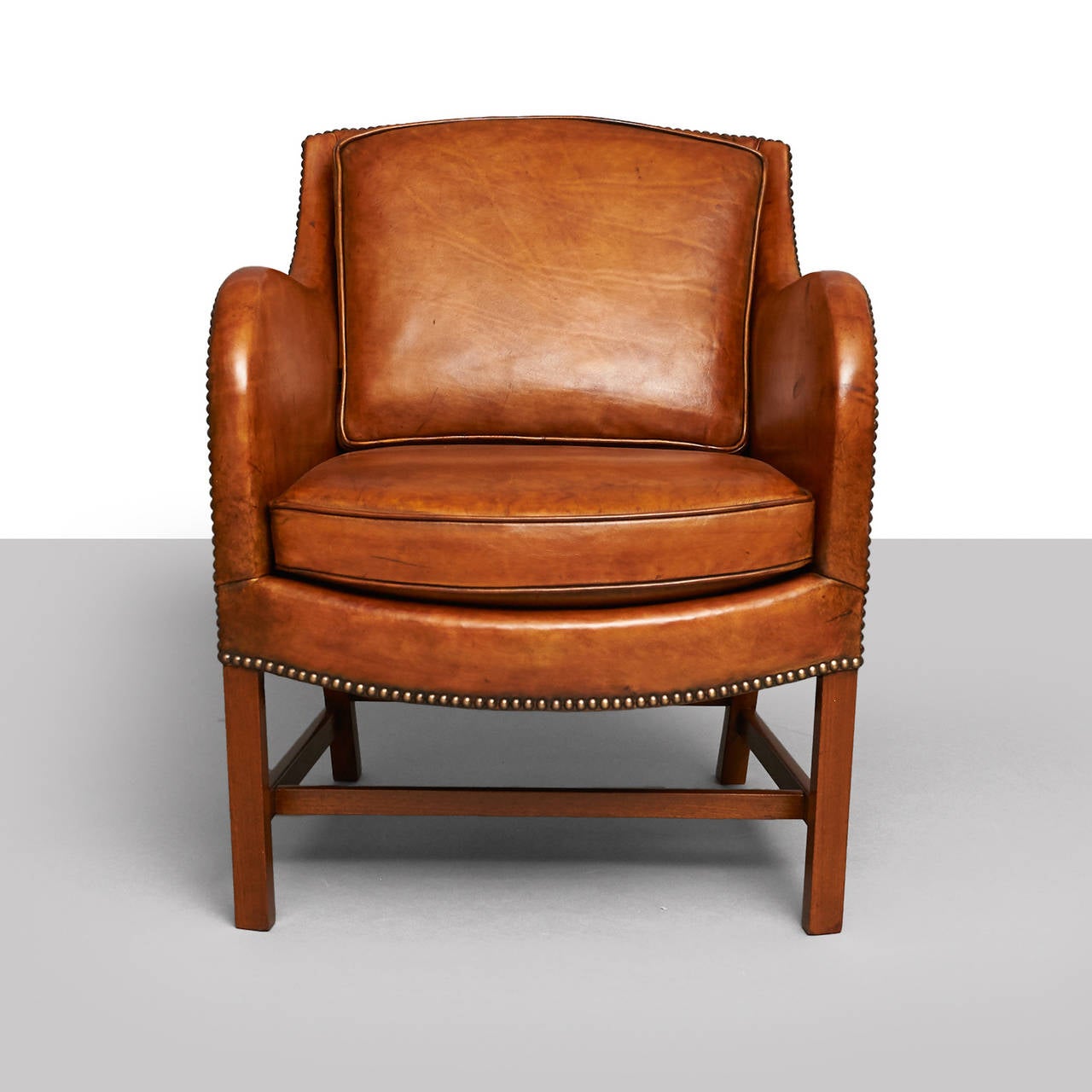 A Kaare Klint and Edvard Kindt-Larsen lounge chair of Cuban mahogany. Restored in antiqued leather. Designed in 1936, produced by Rud. Rasmussens Snedkerier in the 1940s.

Literature: 'Dansk møbelkunst gennem 40 aar: Københavns Snedkerlaugs