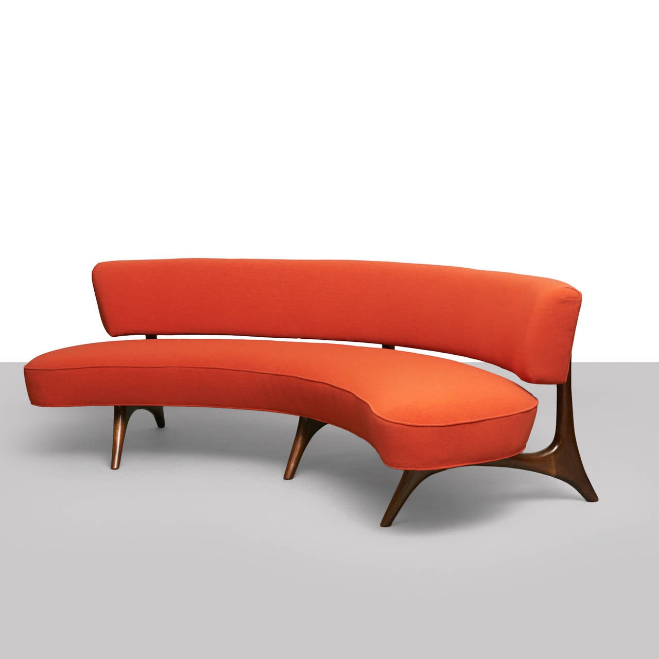 A sofa by Vladimir Kagan in a poppy colored upholstery and walnut frame.
Literature: 
