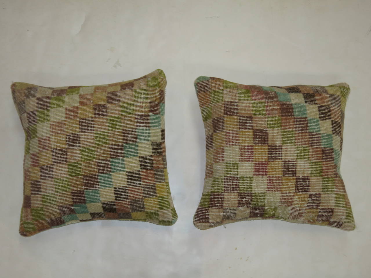 A pair of pillows constructed from a mid-20th century Turkish Anatolian rug backed in cotton measuring 17'' x 18''