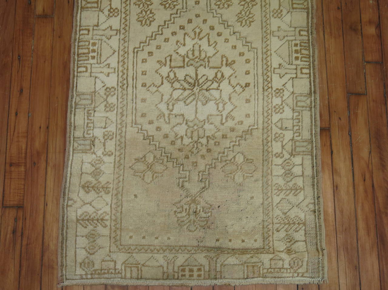 A midcentury Turkish Oushak runner in creams and brown. If you look carefully the border has a motif of various houses.

Measures: 2'5