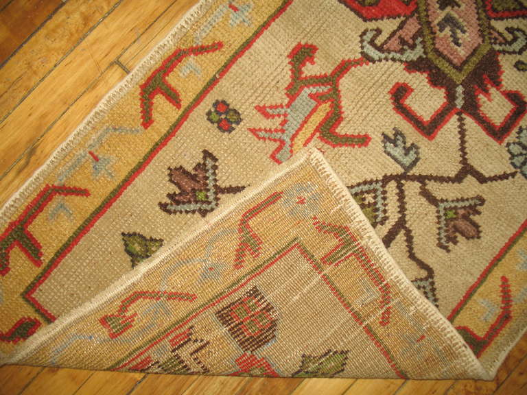 Narrow sized Turkish Oushak runner with an ivory colored field.