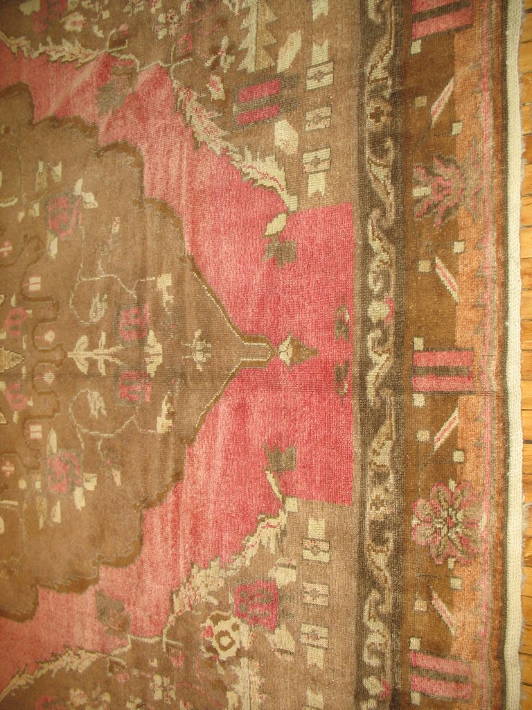 A very unusual and tasteful Turkish rug we found in our recent findings.

Cocoa brown border and central medallion with roses in the field and throughout the medallion all set on a raspberry colored ground. The front border has a slight abrash if