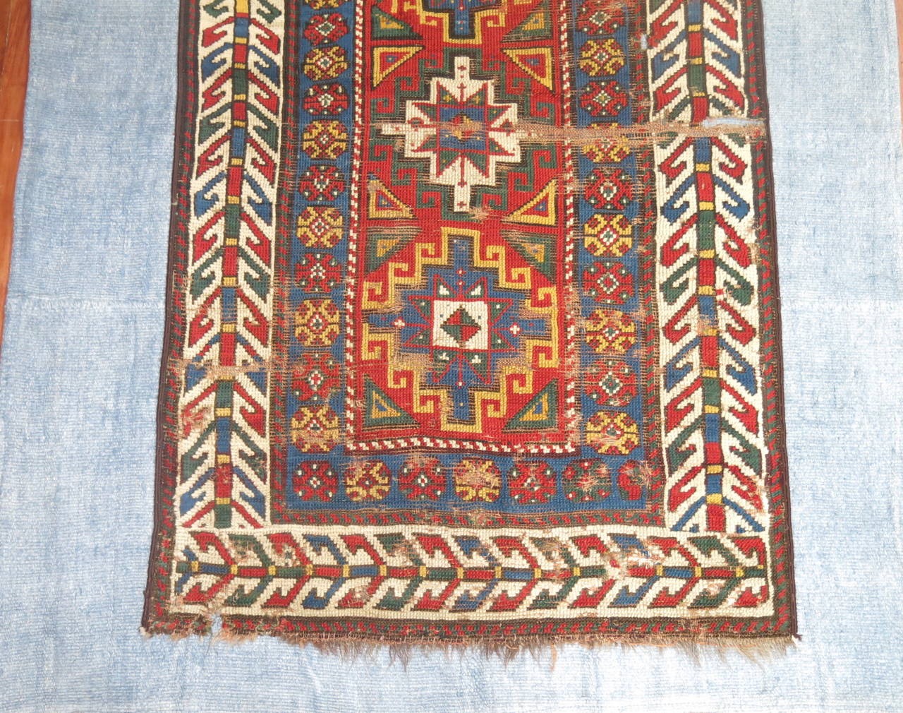 A late 19th century Caucasian Kazak rug stitched onto a light blue Turkish Kilim.