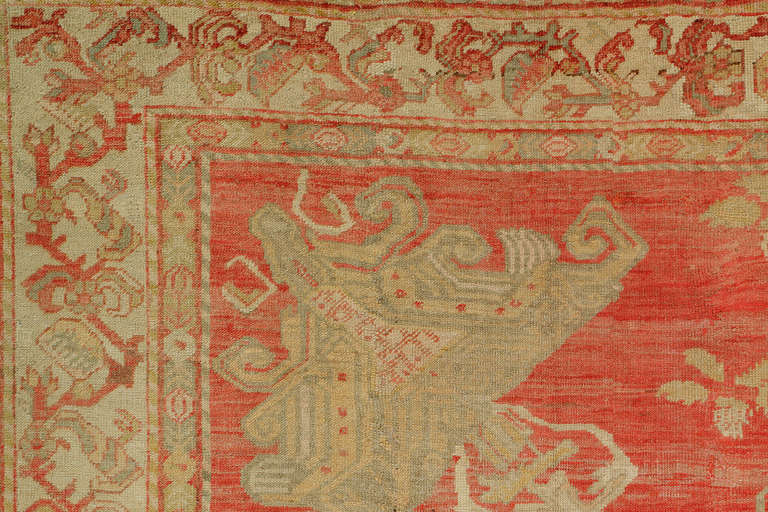 Un tapis turc spectaculaire, unique en son genre, tissé dans la ville de Ghiordes, avec un design stellaire et des couleurs chaudes. L'étonnant médaillon est entouré de rosettes et de sphères céladon sur un fond safrané et une bordure crème.