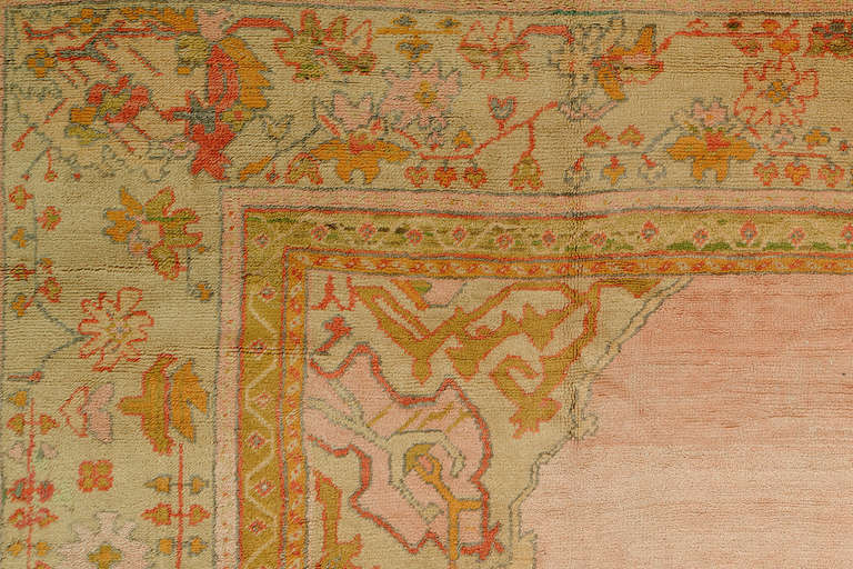 An authentic colorful handmade one of a kind antique Turkish Oushak rug with an open pink field medallion design.