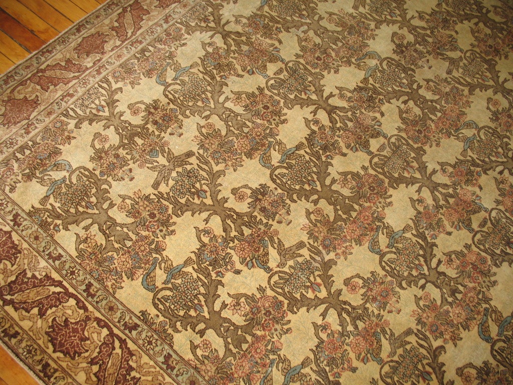 A lovely antique persian tabriz rug featuring a large array of bluebirds facing and showing affection to one another. Flowerpedals and roses also occupy the field lying within a narrow cinnamon border. Impressive craftmanship and technique used