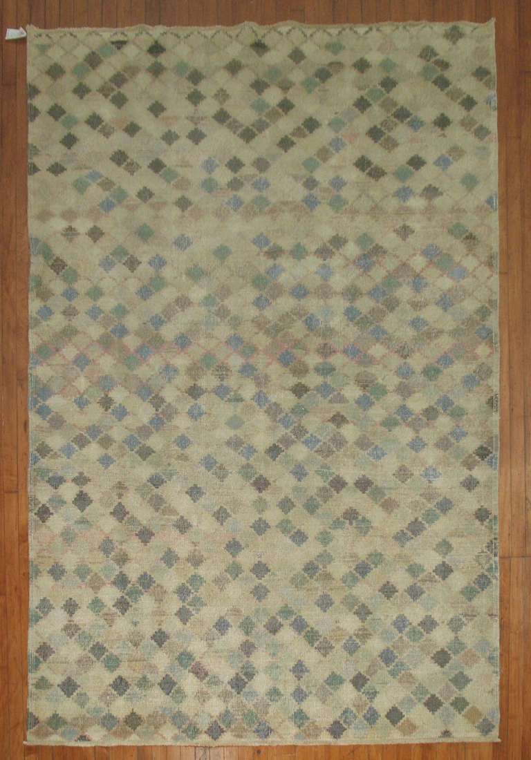 Mid-Century handmade Turkish Deco rug. Earth Toned colors with a small repetitive diamond-shaped motif.

Measures: 6'3'' x 9'8''.