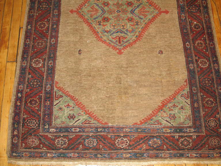A rather grotesque antique Ferehan Persian rug featuring a camel-colored field and a four-corner design motif with a medallion in light green.

3'11'' x 6'7''