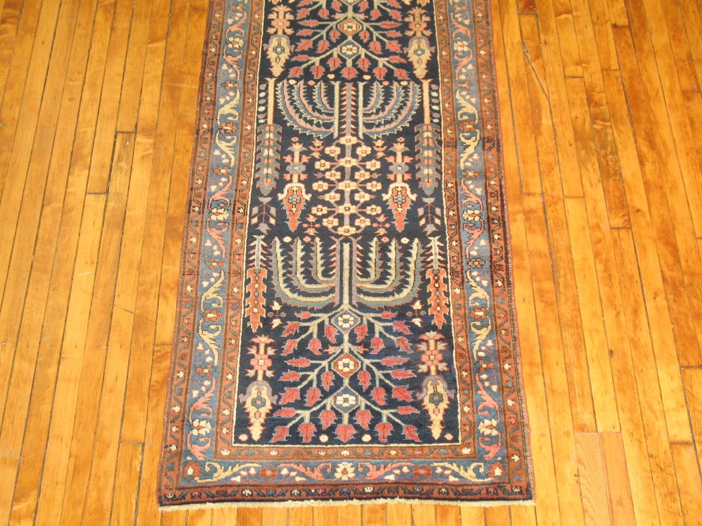 A long antique Persian Tabriz runner featuring a tree of life palette.