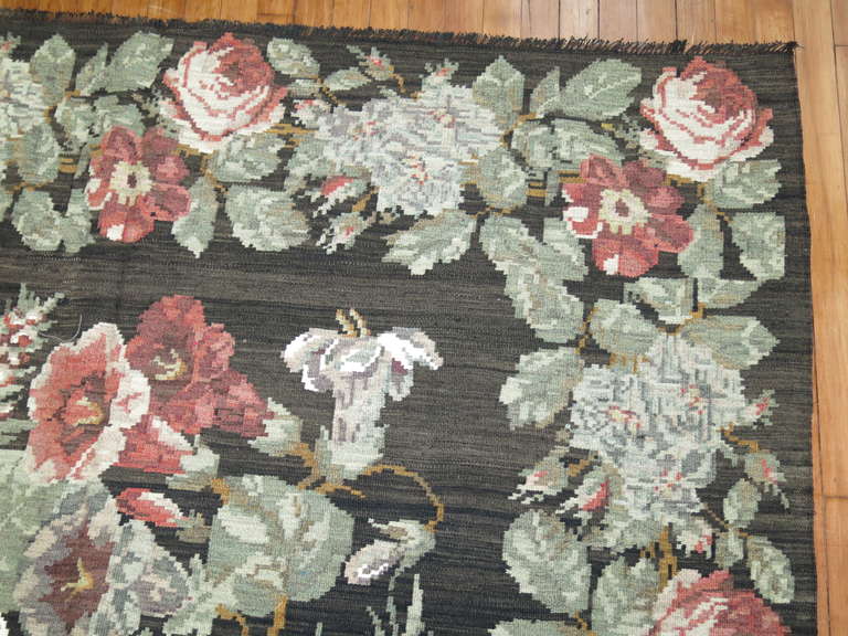 A Mid-Century gallery size Besserabian Kilim with floral elements throughout. Affordably priced.
