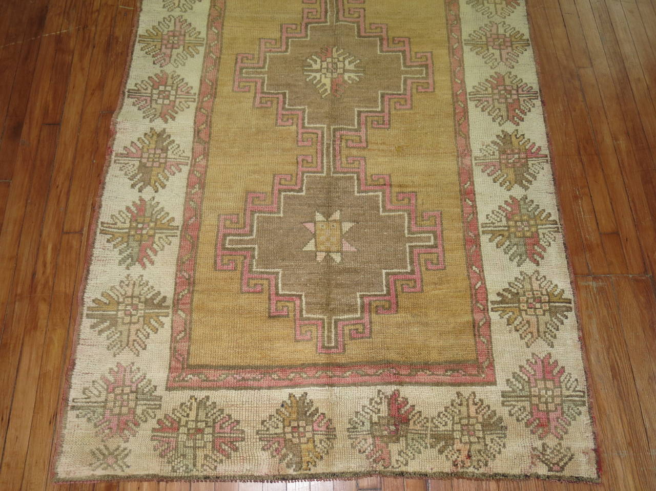 One of a kind Turkish Gallery size runner with a camel field, ivory border, brown medallions with pink accents on field and border.

Measures: 4'6” x 12'7”.